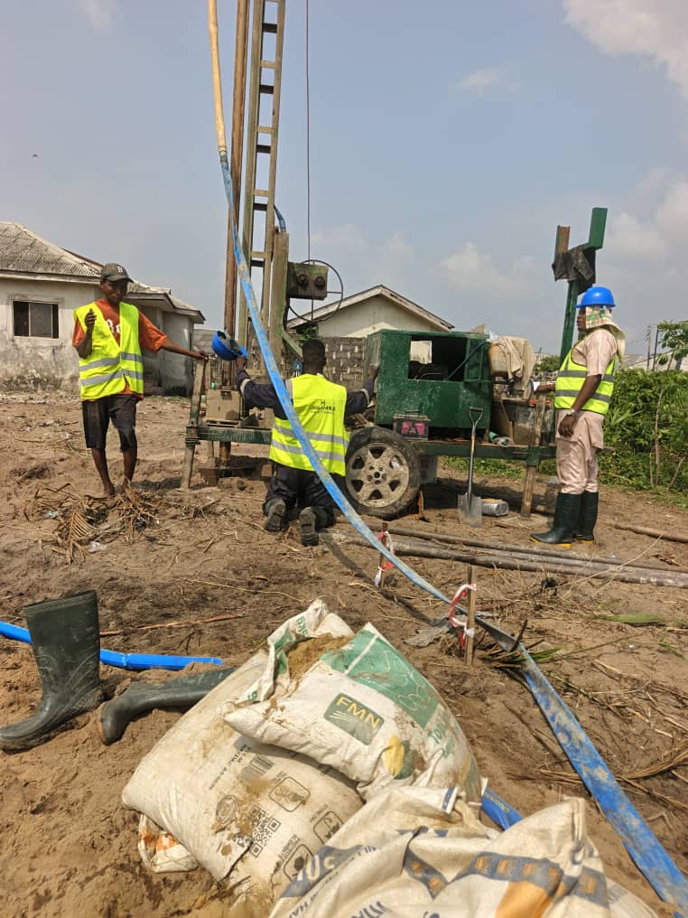 Piling crew with rig and pumped slurry hoses